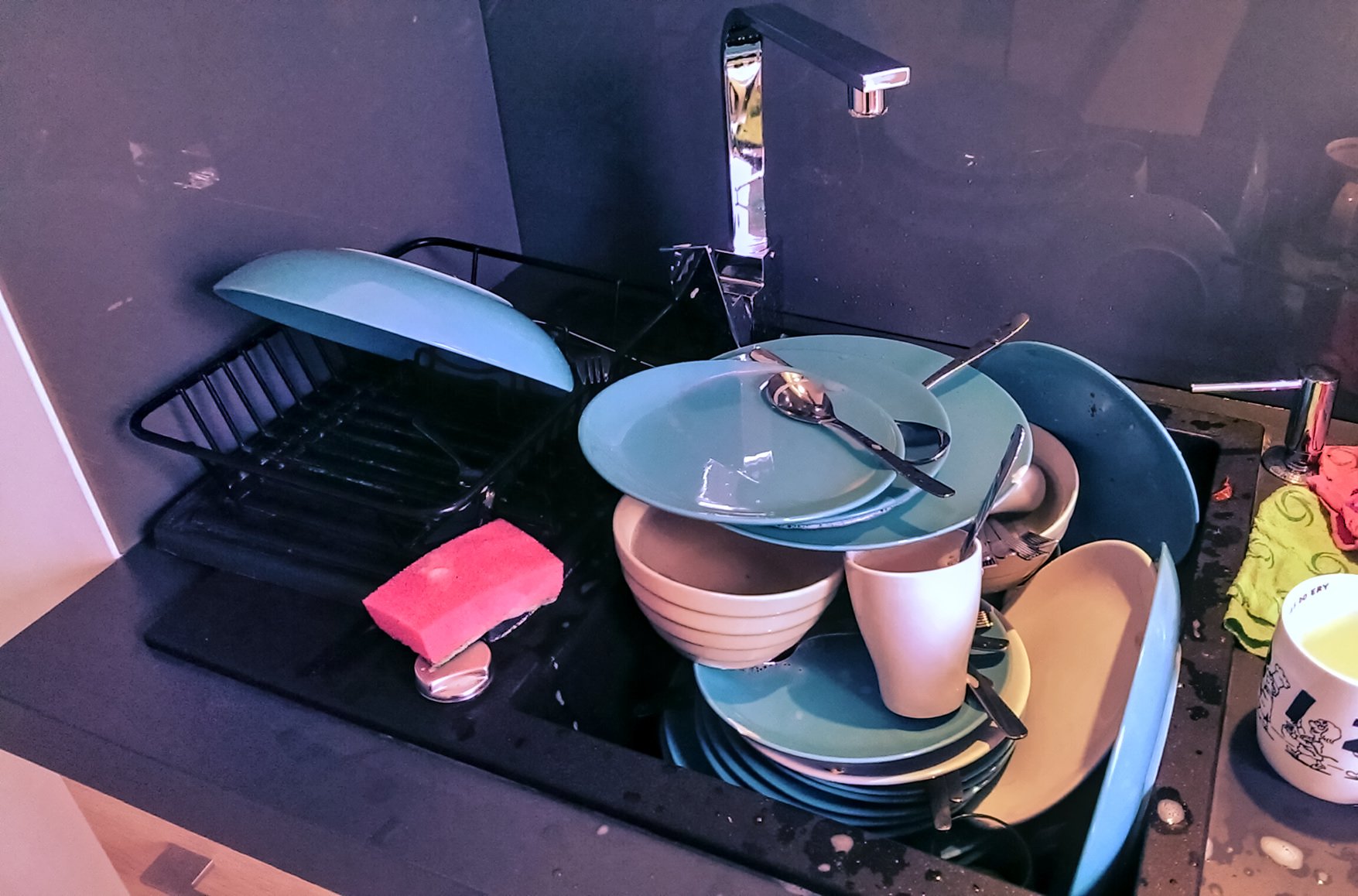 A Pile of Dirty Dishes Left in an Office Kitchen Sink